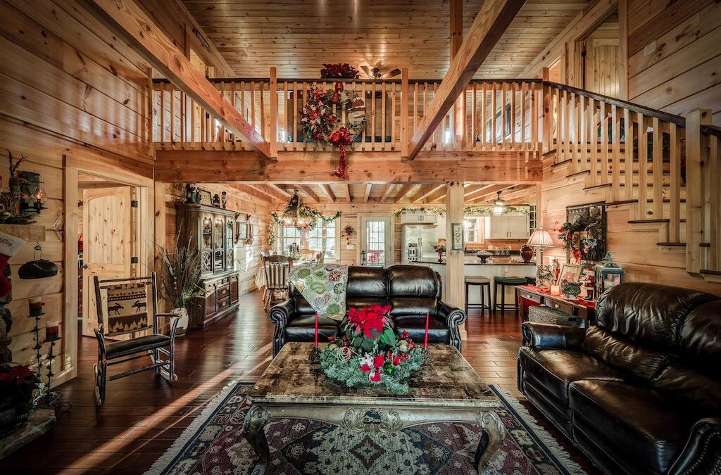 interior of log home with wood stairs, rails, ceilings, walls, floors and open rafters on both uppder and lower level ceilings.