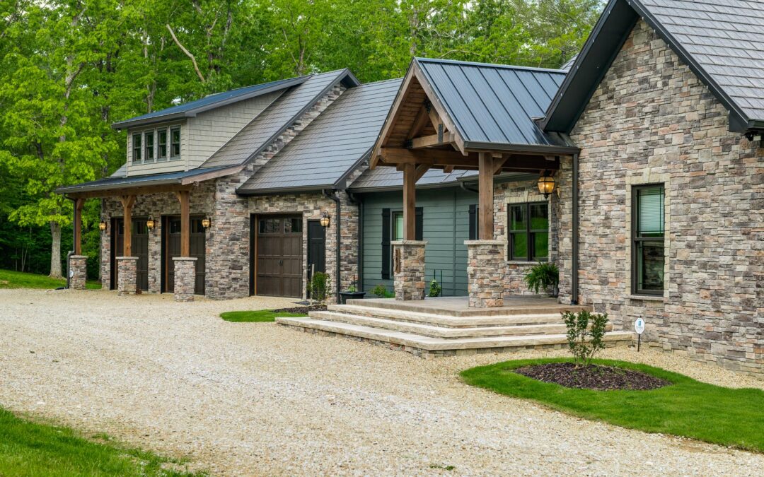 photo of exterior of stone facade timberframe home with attached garage via a mudroom connection